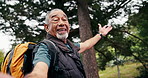 Face, selfie and old man hiking in nature with backpack, recording video and memories of adventure. Happy, senior person and journey outdoor in forest with social media vlog, photography or wellness.