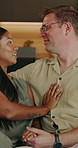 Couple, rest and holding hands at house with smile, love and romantic partner on valentines day. Happy, interracial people and relax in lounge for romance, embrace spouse and affection for commitment