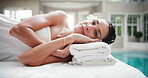Woman, face and relax in spa with peace, comfort and rest on towel for stress relief at resort. Smile, client and mature person on wellness retreat for skincare, self care and bed at luxury hotel