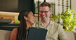 Couple, bonding and laughing with tablet, home and watching movie with subscription in living room. Interracial, relationship and happy people with tech, connection and streaming funny film in house