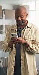 Smile, black man and logistics at startup with phone, email and confirm order for distribution. Happy, mature person and review in office with mobile app, stock availability and delivery of ecommerce