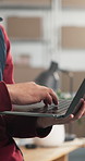 Hands, person and logistics at startup with laptop, stock checklist and confirm order for delivery. Owner, typing or review in warehouse with tech, supply chain and supplier availability for shipping