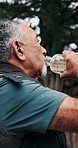 Senior, man and relax with water for hiking hydration, scenic break and nature appreciation. Thirst, pensioner and smile in forest with refreshing liquid, trekking pause or sightseeing with fresh air