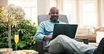 Laptop, remote work and black man at holiday resort to relax, writing blog and internet connection. Smile, technology and digital nomad with drink for workcation, travel or online freelancer at villa
