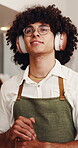 Cafe, barista and man with headphones, music and listening to playlist with subscription or thinking. Streaming, song and happy person with technology, hospitality and waiter with decision in shop