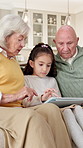 Helping, grandparents and child with tablet in house, talking or digital literacy for senior people. Tech, education and family bonding in lounge, elderly man and old woman with skill development