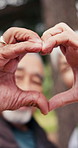 Senior, nature or happy couple with heart hands for hiking passion, love or outdoor romance together. Active, elderly man and woman with emoji, shape or romantic gesture for health and wellness