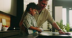 Dad, child and cleaning in kitchen with spray bottle for disinfection, hygiene or chores in home. Father, kid or wiping surface with chemical disinfectant for dirt, bacteria or germ removal in house