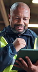Construction worker, smile and man with tablet on building site, inspection or research on website. Low angle, mature builder and happy black person with tech, update and property development on app