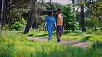Senior, caregiver and walk in forest for cardio, rehabilitation or fresh air in outdoor fitness. Health, carer or old man in woods with physical activity, active aging or support in mobility exercise
