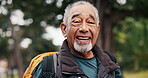Senior, happy man and face in forest for hiking adventure, active retirement and outdoor wellness. Fresh air, pensioner and trekking in woods with smile, nature trail and healthy aging with backpack