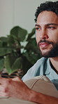 Thinking, phone and man in home with headphones, music streaming and online chat on social media. Happy, contact and person on sofa with tech, playlist planning or post reflection on digital platform