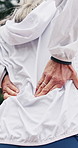 Senior woman, discomfort and back pain for fitness, condition and fatigue of exercise accident. Hands, elderly person and muscle cramps in nature with fibromyalgia, inflammation and training injury