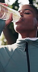 Happy, fitness and black woman with water in nature for hydration, workout break or recovery. Active, female person or mineral liquid with bottle, smile or drink for outdoor rest, health or wellness