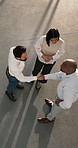 People, meeting and business with handshake in building for proposal, onboarding agreement or deal. Top view, group or employees shaking hands with team for contract, partnership or collaboration