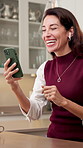 Video call, earphones or woman in house with phone, online connection or conversation in kitchen. Happy, talking or mature person with laugh, digital communication or friendly chat on virtual app.